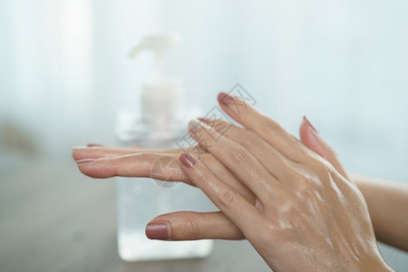 使用洗手液净化剂凝胶泵喷口器的洗手女用于杀死细菌和关心保护干净的图片