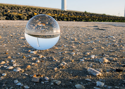 保护在风车公园附近的海滩上水晶和反射着风涡轮素和贝壳创新力量图片