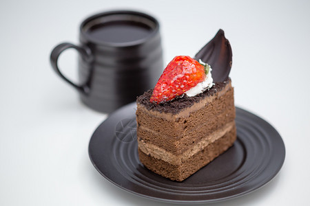 巧克力蛋糕切片在茶碟中草莓紧靠白桌上的咖啡杯好吃肯尼最佳图片