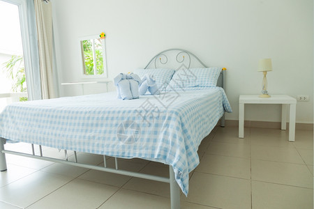 屋枕头现代的床边一盏灯和张蓝毛巾床上用具图片