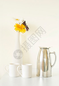 开花美丽的白桌上色杯子和花瓶陶瓷图片