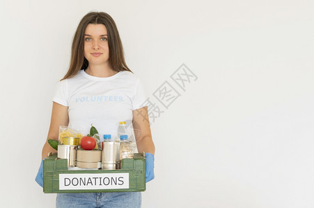 带手套的微笑式志愿者携带装有复制空间的箱装食品捐赠物框架水果图片