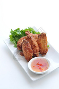 泰国式鸡翅翼烤炒配泰国香草的咸鸡翅辣甜酸酱蟹肉的干净图片
