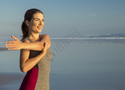 在海滩上做伸展运动的女性图片