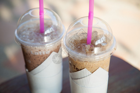 冰镇咖啡的塑料玻璃放在木制桌子上饮料牛奶图片