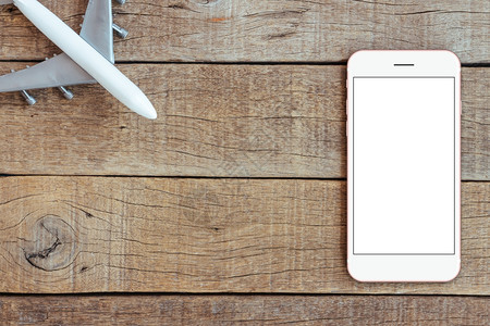 木桌上的电话和飞机玩具运输业务概念顶视图模拟电话空白屏幕实际的干净商业图片