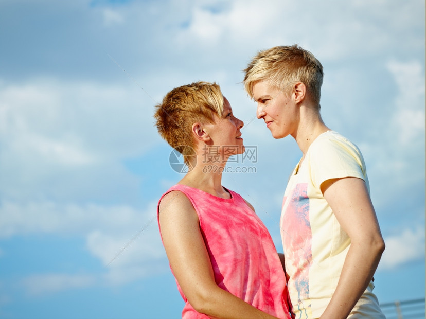 女有两个人在下午的阳光拥抱着两个女人背景是阴云的天空情感女士图片