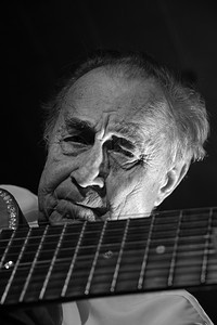 活动男人声学一个穿白衬衫的老人弹着声音吉他黑暗背景单色图片