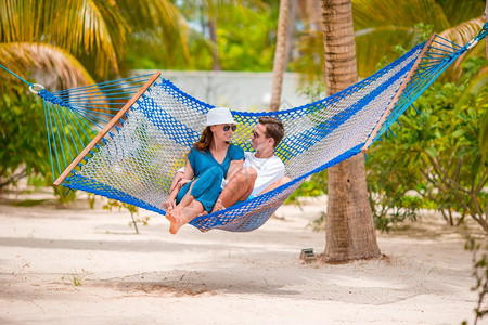 家庭在沙滩度假的吊床上放松家庭在暑假吊床上放松休息乐趣采取天堂图片