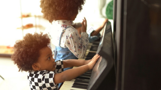 美丽的非洲小孩们在弹钢琴演奏音乐古典家年轻的图片