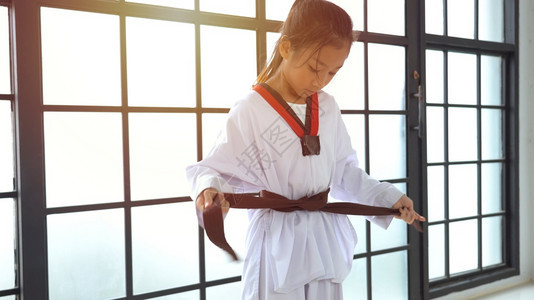 战斗机年轻的亚洲女孩在演播室结了一条黑带制服武术图片