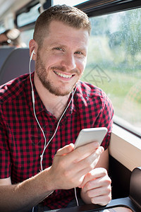 年轻人在工作旅程中通过移动电话聆听音乐的青年之旅运输连接的图片