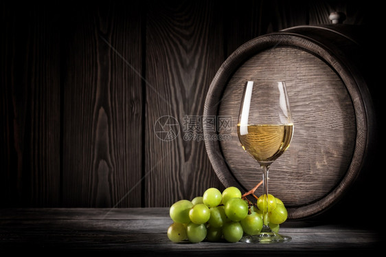 饮料木桶背景上的玻璃白葡萄酒和串玻璃白酒和串橡木庆祝的图片