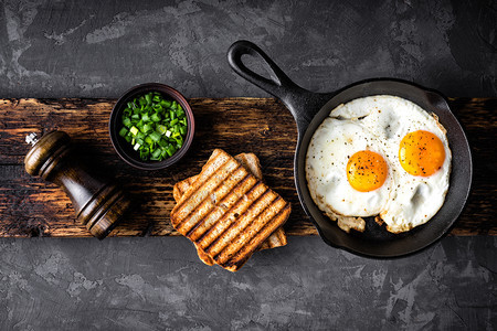 敬酒一种为了早餐或午煎鸡蛋用黑椰子和脆烤面包制成带有文字空间的顶视图图片