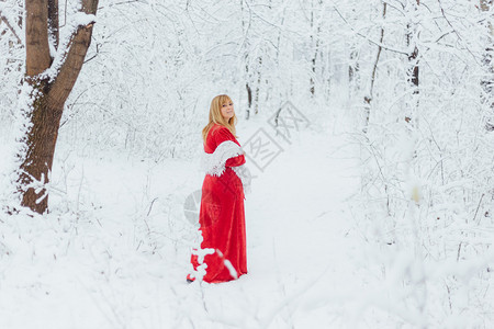 时尚美丽的在寒冷森林里穿着红裙子的女人色图片