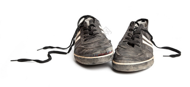 在白色背景上被孤立的肮脏旧黑色运动鞋靴子开机脚丫图片