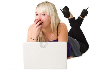 健康白色的愉快在吃苹果时这里用笔记本电脑的年轻美女白种背景图片