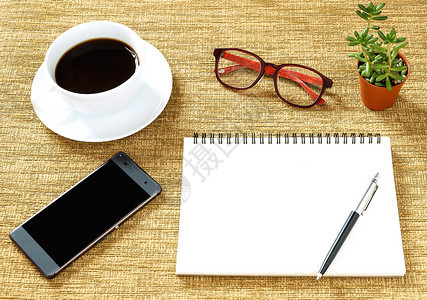 木制的展示棕色背景上的笔记本咖啡杯和眼镜的顶端视图信息图片