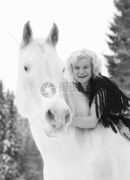 迷人的金发美女拥抱白马过冬日哺乳动物天女图片