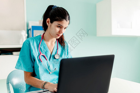 医院听诊器所使用膝上型电脑的女医生桌子图片