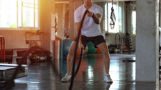 积极的男子在运动训练健身体育场有战斗绳室内的功能图片