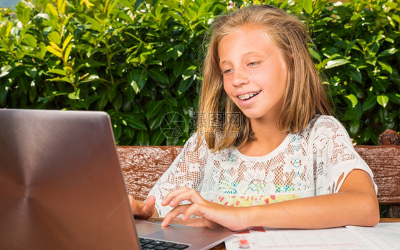 年轻的人们眼睛10岁的漂亮女学生在计算机上学习的幸福快乐图片