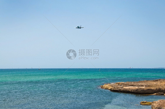 地中海在西班牙马洛卡的阳光明媚暑假日飞机从地平线海景上空坠落浪漫的丰富多彩图片