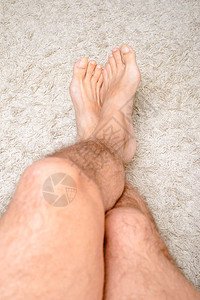 冬天一个男人在放松脚踏暖的羊毛地毯上腿长了毛地面休息图片