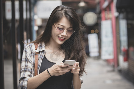 互联网沟通美丽的年轻女人在智能手机上用微笑的面容阅读信息自由职业者图片