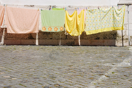 典型的里斯本风景与衣服干燥在人行道上脚下石棺泥路面卡尔达葡萄牙洗衣店图片