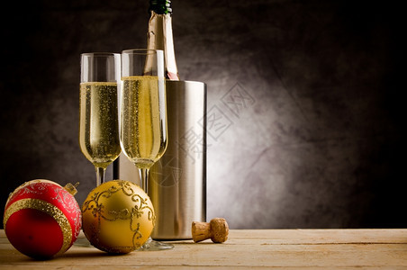 木制的假期球带有圣诞节装饰品的木桌上香槟杯眼镜图片