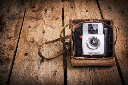 复古的一个老照相机在它原来的旧皮革箱子里用木制背景抽象的照片图片