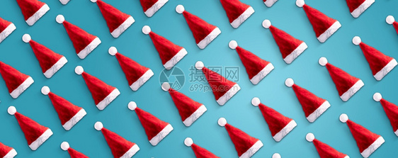 垂直的蓝色躺着桑塔克圣诞老人帽子在蓝色背景上具有创意的型式最低冬寒公寓是圣诞节概念全景形象图片