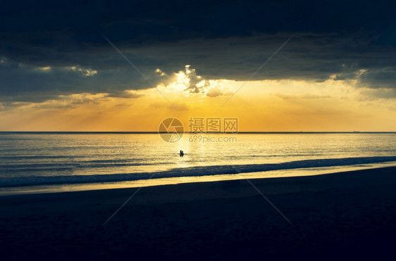 景观金子黄昏时的海景和日落以及人们在水中玩耍晚上图片