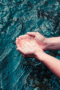 反射液体小男孩从河里取纯净水把它握在手里波纹图片