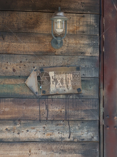 在Ventage油灯出口标志和Wintage油灯附近的Wooden框架箭头上的退出信号和绿箭门单词定向的图片