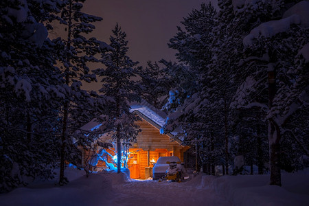 冬季夜晚森林中亮灯的木屋图片