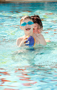 母快乐的亲和儿子在游泳池里玩白种人活动图片