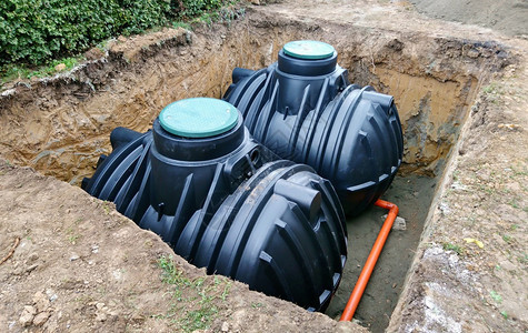 一种为雨水收集工作在地下铺设的两座塑料储存库用于收集雨水肮脏的黑色图片