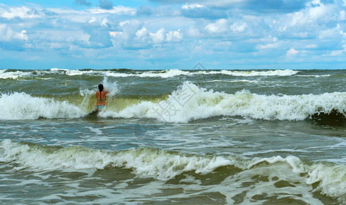 海滩一种自然女孩在海浪中沐浴上风暴中游泳在海上风暴中游泳女孩在海浪中沐浴图片