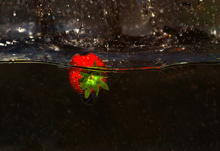 绿色摄影食物在水中新鲜的草莓黑色背景有喷洒接近水平视图图片