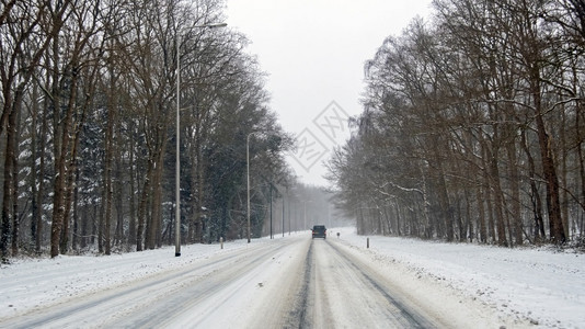 危险阿姆斯特丹下雪在荷兰一条乡村公路上暴风雪中驾车图片