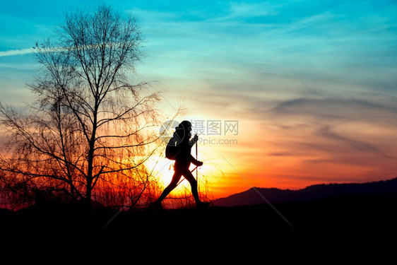 高山户外北欧人走在山上日落时一个女孩的彩色背影天空图片