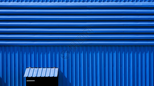 空气在蓝色仓库建筑墙上打开铝润滑窗和钢颜色床单图片