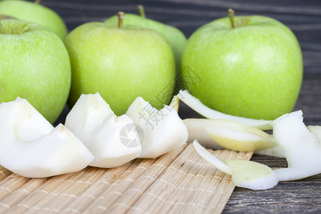 白色的出去烹煮一盘苹果的厨房桌菜是绿色的苹果一部分切成片苹果的剥皮核心被全部切成一片多汁的图片