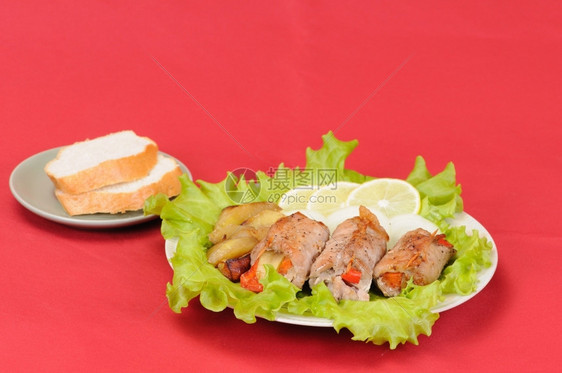 猪肉水平的轧制沙拉叶上肉面包加柠檬和洋葱图片