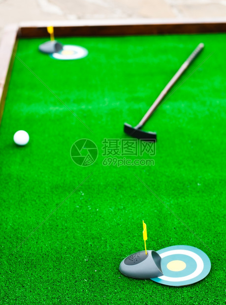 洞娱乐人造的带有球和高尔夫俱乐部的小型高尔夫球场图片