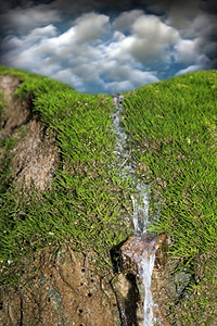 绿苔和蓝天空背景的小型瀑布荒野蓝色的降低图片