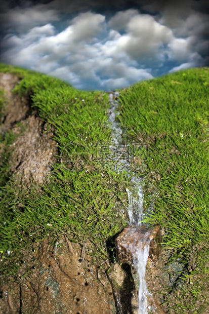 绿苔和蓝天空背景的小型瀑布荒野蓝色的降低图片