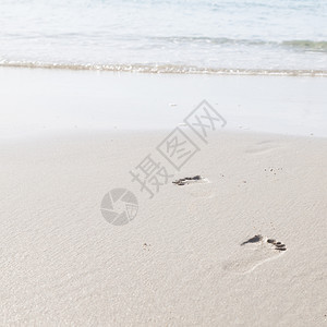 在海边滩上行走的人们脚足迹印在沙滩上的脚浪漫热带小路图片